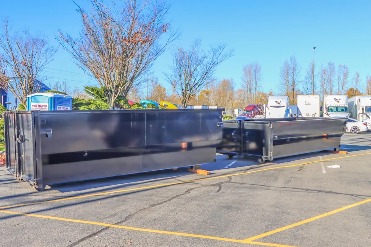 Professional dumpster rental service with roll-off container on residential driveway in Moorhead